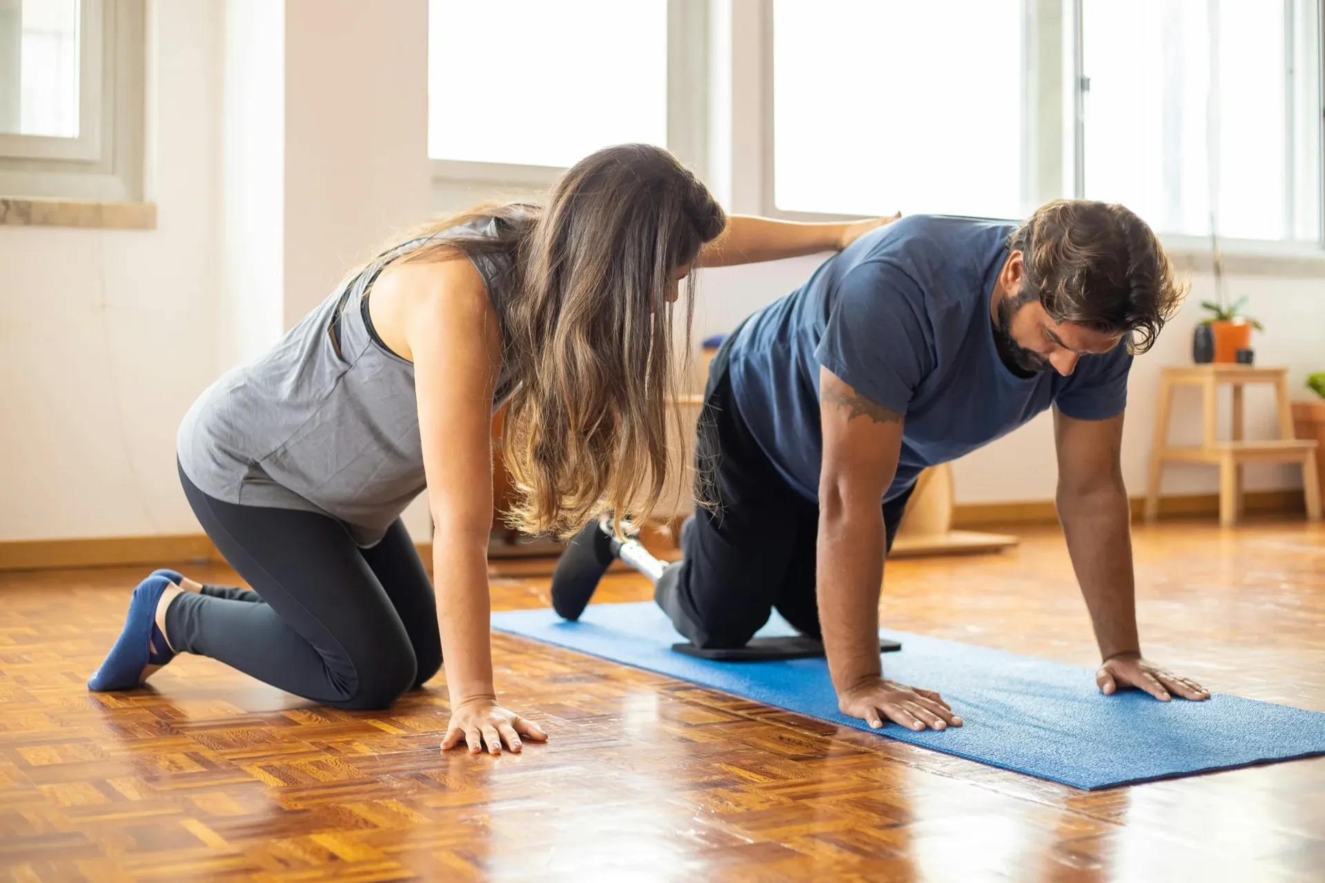 Clinician guiding a client through a supported movement assessment during rehabilitation